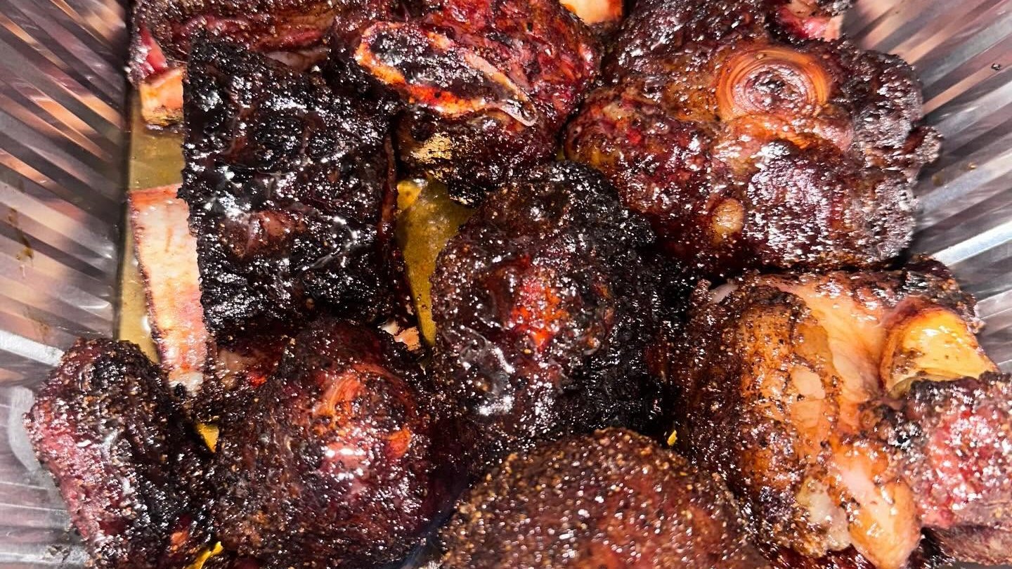 Charred rib tips piled high, glazed and steaming