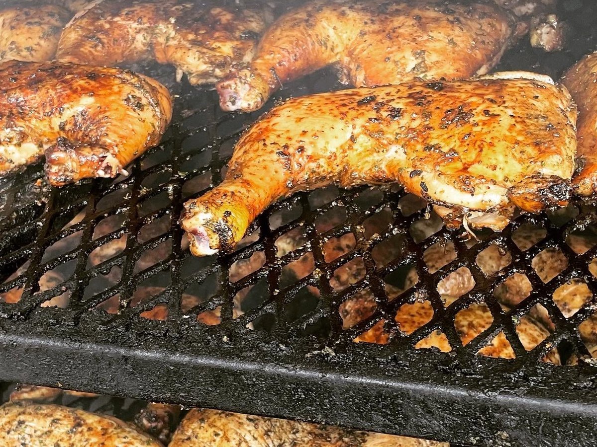 Chicken quarters cooking on the smoker grate