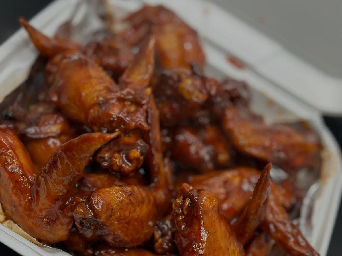 Smoked chicken wings with a glossy garlic glaze on a white plate